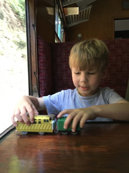Boy on train playing with toy train