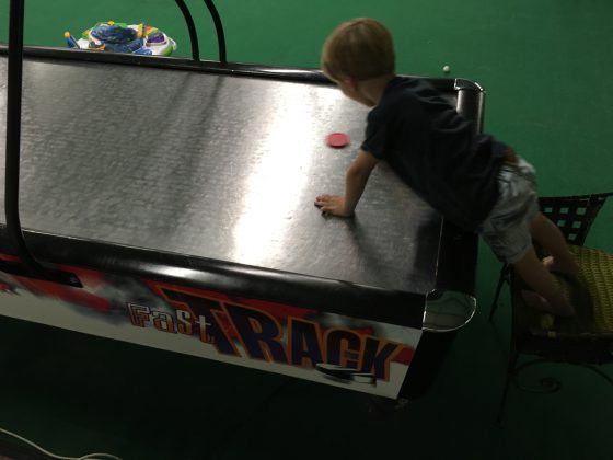 The boy's first game of air hockey. He thought it was hilarious every time he let a goal in!